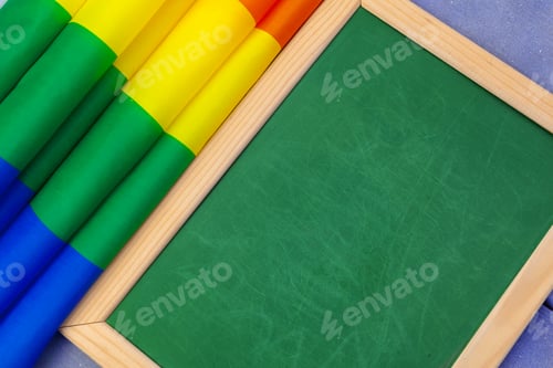 Preview: Bright rainbow gay flag on wooden background and blank space