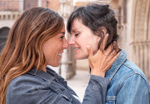 Preview: close-up of a young lesbian couple on the street kissing, gay concept