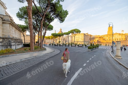 Preview: Woman walking with a dog on the famous central street in Rome