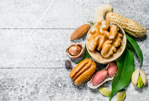 Preview: Various nuts with green leaves.