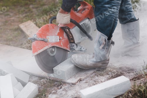Preview: Worker mason cuts the sidewalk tile with circular saw while repairing sidewalk in city street
