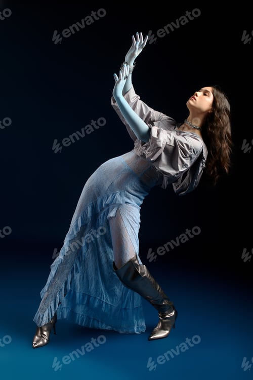 Preview: Stylish young woman showcases unique fashion in a dynamic studio pose