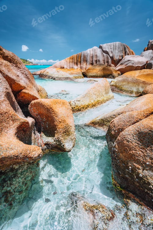 Preview: Bizarre shaped rocks in blue ocean water on Anse Cocos beach, La Digue island, Seychelles