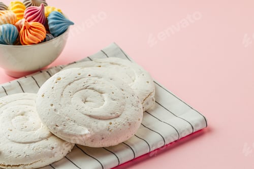 Preview: White meringue cookie on pink background with colorful mini meringues