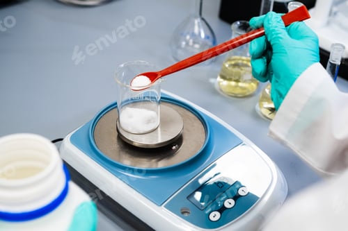 Preview: Close up of a woman weighing powder samples using laboratory balances.