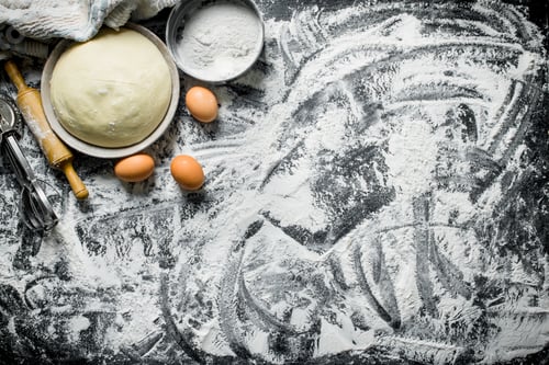 Preview: Dough in bowl with eggs, rolling pin and flour.