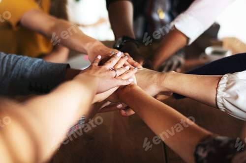 Preview: Hands joined over wooden table