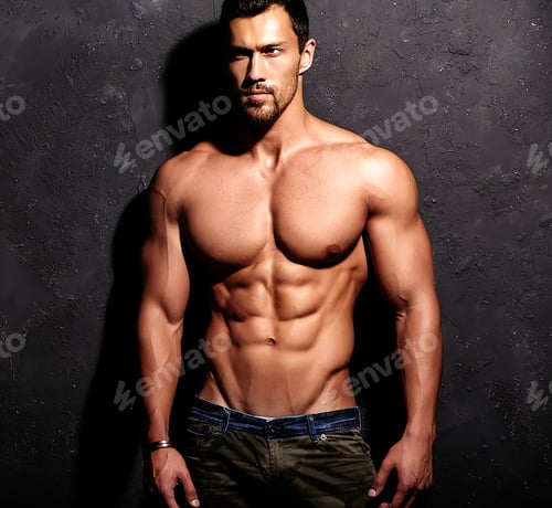 Preview: Portrait of young strong man with perfect sportive body posing in studio