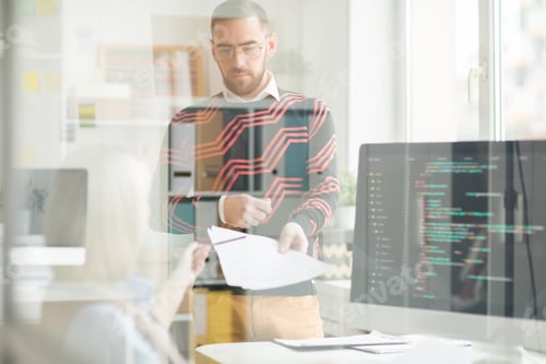Preview: Serious man giving papers with code to lady programmer