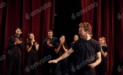 Preview: Group of actors in dark colored clothes on rehearsal in the theater