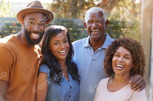Preview: Portrait of Family With Adult Parents With Grown Up Son And Daughter Relaxing In Garden At Home