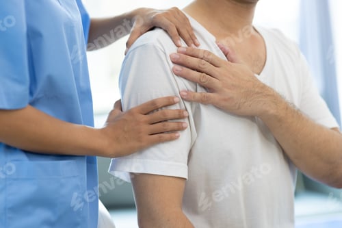 Preview: Doctor diagnosing man's shoulder pain in hospital examination room.