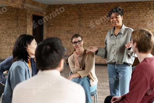 Preview: Young business coach leading a team meeting in a modern office