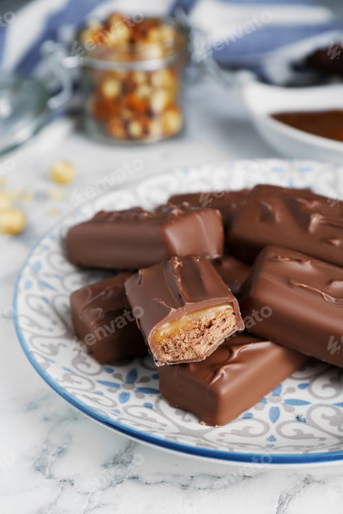 Preview: Delicious chocolate candy bars on white marble table, closeup