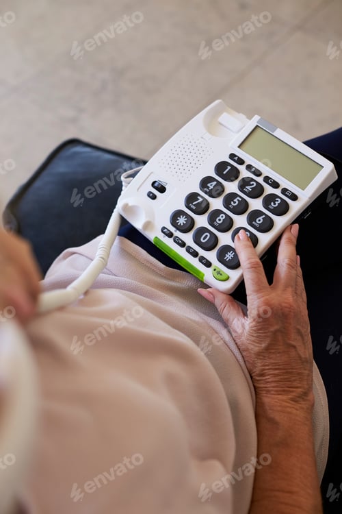 Preview: Senior Woman At Home Using Telephone With Over Sized Keys