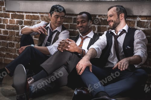 Preview: group of smiling stylish businessmen resting together after work