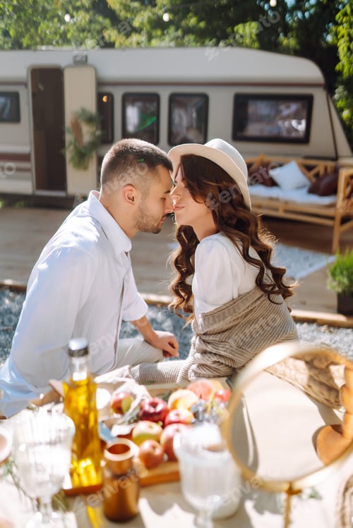 Preview: Beautiful wedding couple laugh and kiss relaxing in rv, camping in a trailer. Romantic moment.
