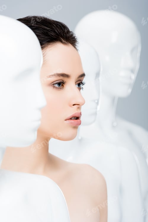 Preview: selective focus of beautiful girl posing near mannequins isolated on grey