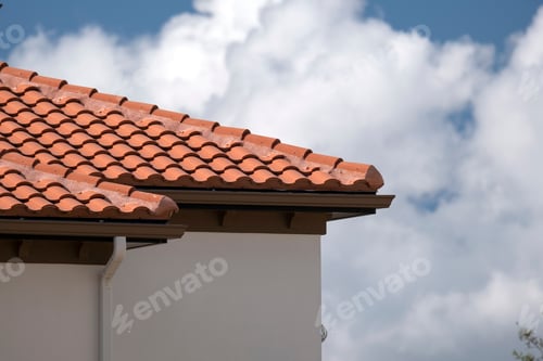 Preview: Overlapping rows of yellow ceramic roofing tiles covering residential building roof