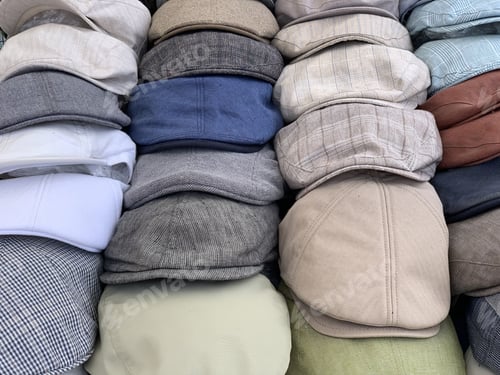 Preview: Neatly arranged pile of newsboy caps with different patterns in a shop
