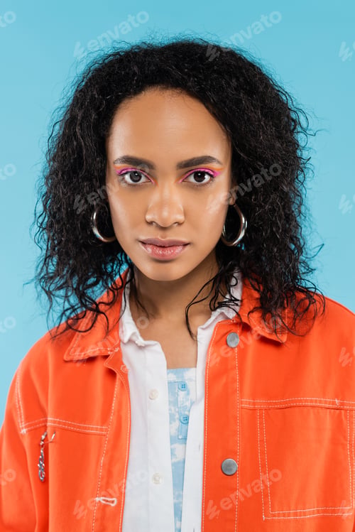 Preview: portrait of african american woman with wavy hair and bright makeup looking at camera isolated on
