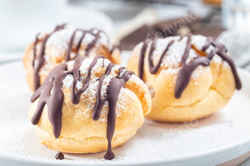 Preview: Closeup of homemade profiteroles with whipped cream and chocolate filling, horizontal
