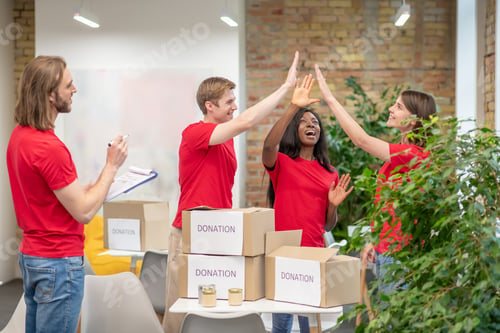 Preview: Young volunteers in red tshirts at work in a distribution point