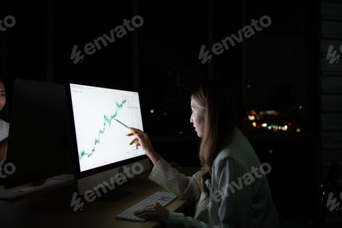 Preview: Both of young Asian broker international stock traders working together on desktop at night office,