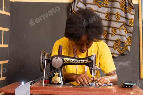 Preview: Female African tailor sewing with her machine
