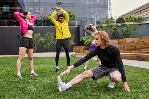 Preview: Sporty young individuals engage in stretching exercises outdoors at a modern city park