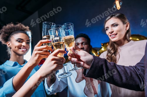 Visualização: visão de perto de felizes jovens amigos multiétnicos tilintando taças de champanhe