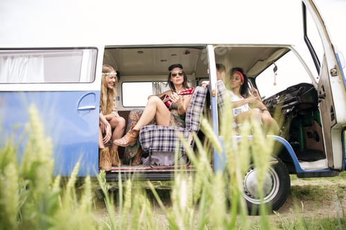 Preview: Happy friends driving a vintage minivan
