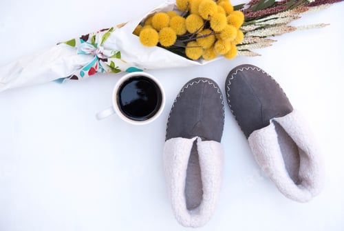Preview: Flat lay of a pair of slippers and a cup of a coffee with a bouquet of flowers