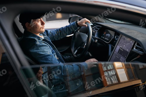 Preview: Guy driving car using touch screen on control panel.