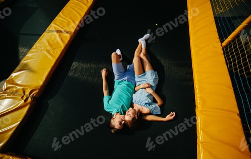 Preview: Couple lie on trampoline in the park