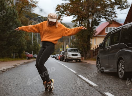 Preview: girl dancing on the road on her toes yellow sweater