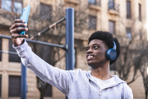 Preview: Selfie of african american young male with blue headphones. Sportswear. Sport concept.