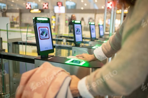Preview: Crop woman using smartphone while scanning info into smart gate pass in airport