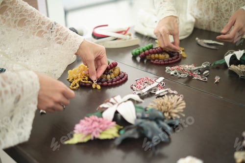 Preview: A person arranges colorful beaded necklaces and jewelry on a table. This image showcases the beauty