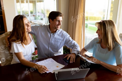 Preview: Young couple discussing with a financial adviser at home