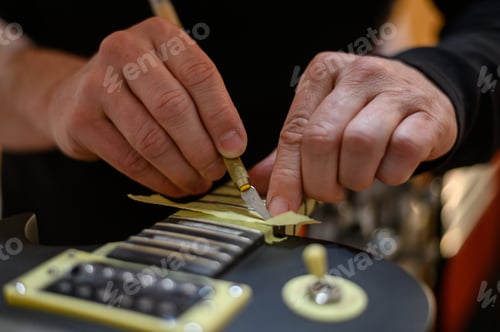 Preview: Master guitar luthier hands polishes the frets on the fretboard