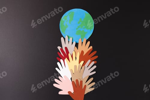 Preview: Paper cut out of multi coloured hands and globe with copy space on black background