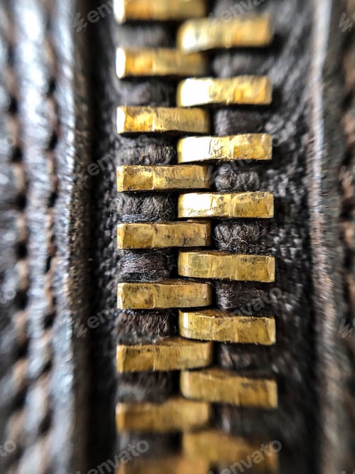 Preview: Closeup macro shot of brass zipper on brown leather