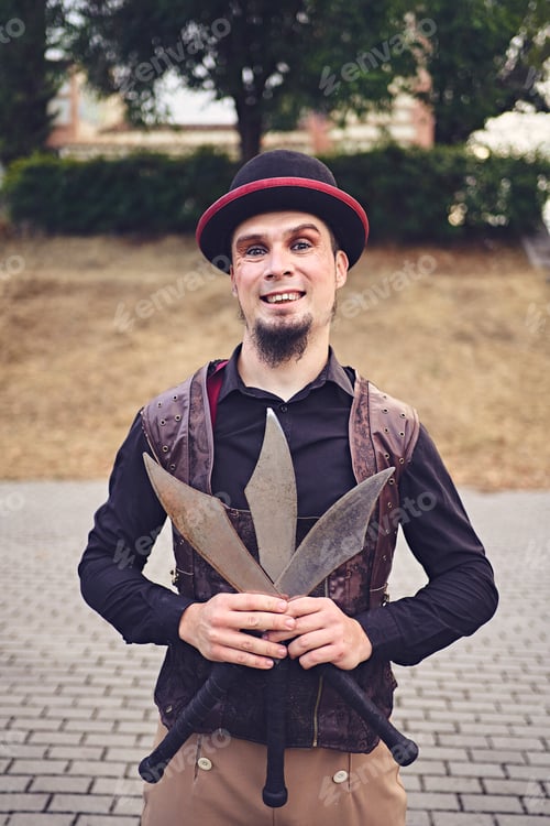Preview: Cheerful juggler with knives in park