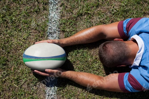 Preview: Rear view of rugby player holding ball on goal line