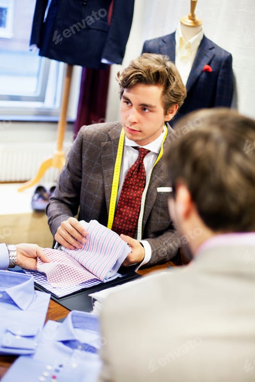 Preview: Customer and fashion store owner discussing fabric swatch at boutique
