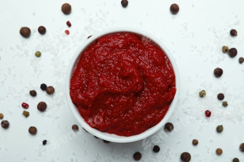 Preview: Bowl with tomato paste, pepper and salt on white background