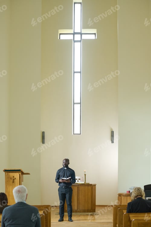Preview: African American priest in black casualwear making sermon for parishioners