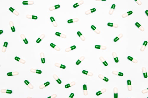 Preview: Pharmaceutical and health concept, Antibiotic capsules in green white arranged on white background