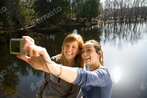Preview: Two women with camera beside lake